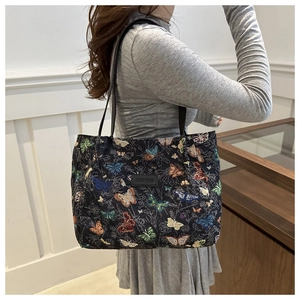 Detailed view of tote bag with butterfly embroidery and woven fabric texture