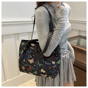 Close-up of vintage canvas tote bag with colorful butterfly embroidery and leather logo
