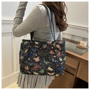 Detail of colorful butterfly jacquard tote bag with leather logo and black straps