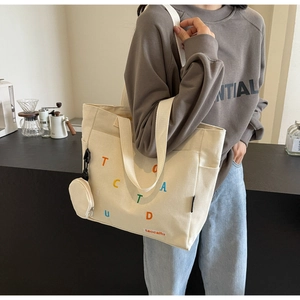 Dettaglio della borsa tote in tela con lettere colorate e piccolo portamonete rotondo