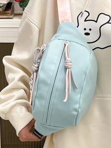 Detail der hellblauen Nylon-Umhängetasche mit rosa Gurt und verknoteten Reißverschlüssen