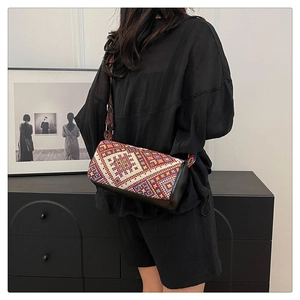 Dettaglio borsa a secchiello boho con motivi etnici colorati e ampia tracolla