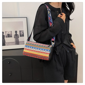 Ricamo dettagliato su borsa a secchiello boho con motivi colorati e tracolla larga
