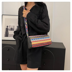 Dettaglio borsa a secchiello boho con ricami geometrici colorati e tracolla larga