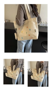 Dettaglio della borsa tote in tela bianco sporco con stampa di lettere e mini borsellino