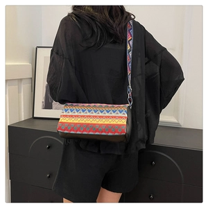 Dettaglio borsa a secchiello boho con trama etnica colorata e ampia tracolla floreale