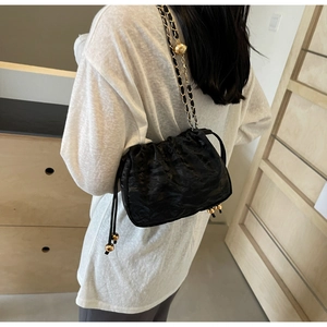 Borsa a nuvola nera a pieghe con catena dorata e coulisse per donna elegante