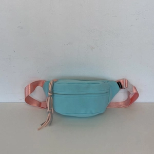 Detailansicht der pastellblauen Umhängetasche mit rosa Gurt und FASHION-Label