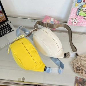Detailansicht der großen Crossbody-Brusttaschen aus gelbem und weißem Canvas-Stoff