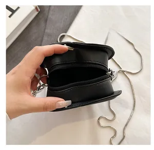 Detail view of the zipper opening and interior of black heart chain crossbody bag