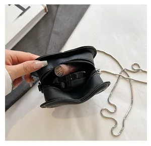 Close-up of heart-shaped mini chain bag showing interior space for lipstick and makeup