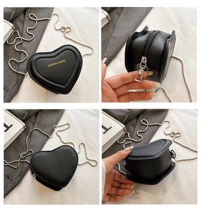 Detailed views of mini black heart-shaped crossbody bag with gold lettering and silver chain