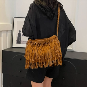 Borsa a tracolla boho in camoscio marrone con frange e tracolla intrecciata su modello