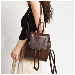 Dettaglio dello zaino vintage marrone scuro con patta magnetica e chiusura a coulisse interna