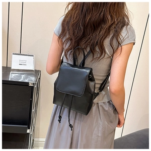 Vista posteriore dettagliata di una donna con il piccolo zaino in pelle nera con coulisse