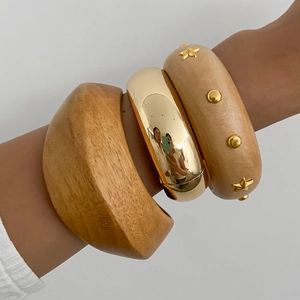 Close-up of bohemian bangle set featuring natural wood textures and gold metallic finishes
