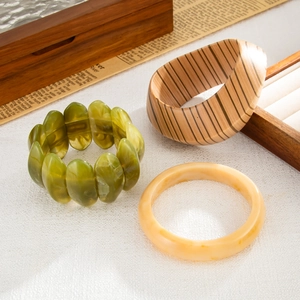 Detailed shot of ethnic style bangles with wood texture and green resin beads