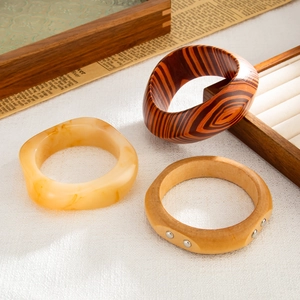 Detail view of ethnic resin and wood texture bangles with metallic stud accents