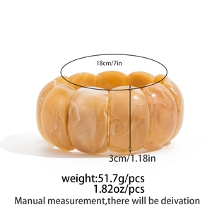Detail view of amber marble textured wide resin bangle with dimensions and weight specs