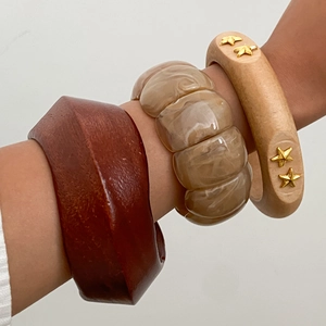 Close-up of Bohemian wood and marble texture bangles set with gold star accents