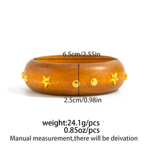 Dettaglio di un bracciale largo in legno marrone con stelle dorate e diametro 6,5 cm