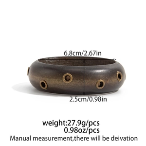 Dettaglio del bracciale texture legno irregolare con borchie dorate e misure