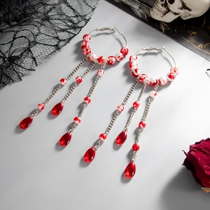 Detailed shot of gothic blood pearl earrings with silver hoops and red teardrop tassels