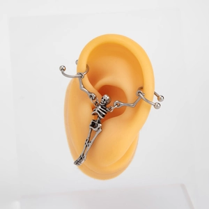 Orecchino punk gotico a forma di scheletro in argento vintage su un modello di orecchio