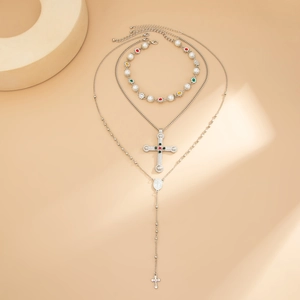 Dettaglio della collana a strati con croce d'argento e bracciale di perle con gemme