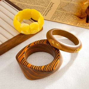 Dettaglio di bracciali bohémien in resina e legno con stella su un supporto espositivo