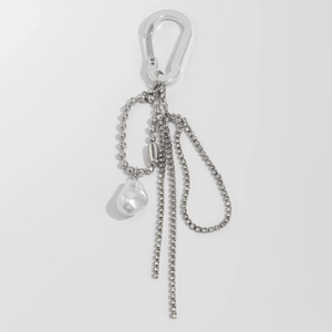 Close-up of silver keychain with baroque faux pearl and long sparkling tassel chains