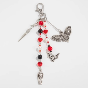 Gothic beaded pant chain with silver moth, bat and coffin charms on a white background