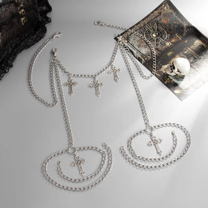 Detailed view of silver gothic body chain featuring ornate cross charms on a black lace