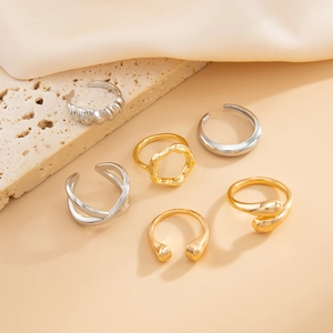 Detail of minimalist gold and silver ring set featuring woven and geometric textures