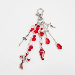Detailed macro of Gothic keychain with red crystal beads, cross, and coffin charms