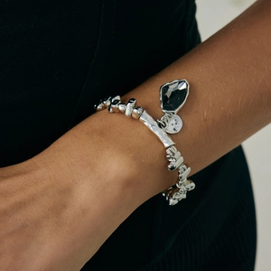 Dettaglio del bracciale a catena d'argento con ciondolo in pietra acrilica nera