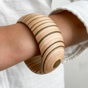 Bracciale rigido largo irregolare in legno naturale con venature distinte su modello