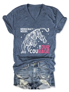 Dettaglio della t-shirt con scollo a V, stampa tigre e pantaloncini in denim strappati