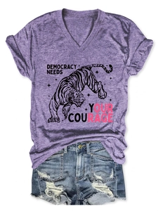 Dettaglio della t-shirt viola con scollo a V, stampa tigre e pantaloncini di jeans