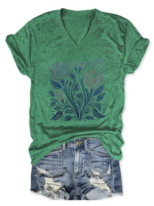 T-shirt verde scollo a V con stampa floreale abbinata a pantaloncini di jeans