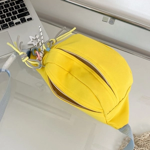 Detail der gelben Canvas Gürteltasche mit Sternanhänger auf modernem Schreibtisch