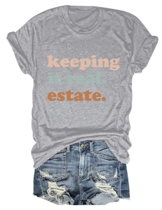 Dettaglio di t-shirt grigia con testo colorato e pantaloncini in denim strappati casual