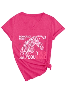 Dettaglio maglietta rosa con scollo a V, stampa tigre bianca e scritta Democracy Needs Your Courage