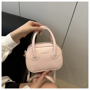 Close-up of pink PU leather handbag showing top handle and fashion logo lettering