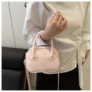 Close-up of pink Boston bag with FASHION & BAGS logo and golden hardware details