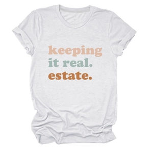 Dettaglio della stampa keeping it real estate su t-shirt bianca in cotone girocollo