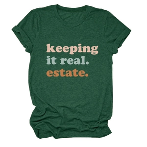 Dettaglio in piano della T-shirt girocollo verde scuro con scritta 'keeping it real estate'