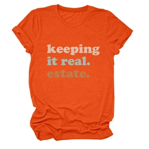 Dettaglio dello slogan keeping it real estate su maglietta arancione a girocollo