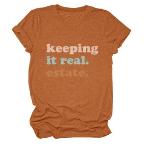 Dettaglio della maglietta girocollo arancione con lo slogan 'keeping it real. estate.'