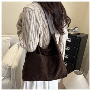 Grand sac cabas en daim marron foncé avec poches porté par un mannequin en intérieur